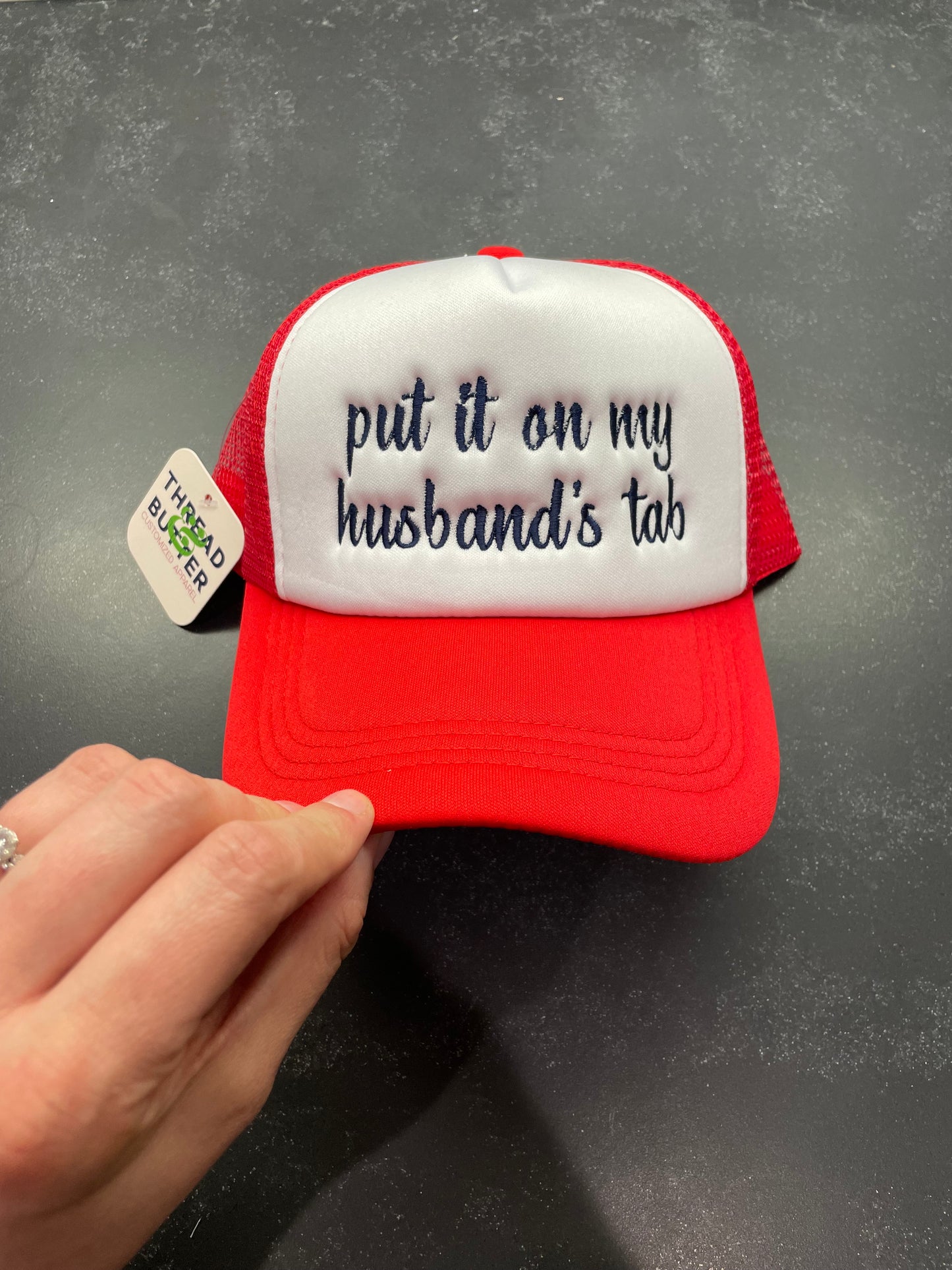 Put It On My Husband’s Tab Trucker Hat
